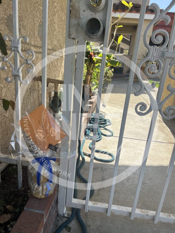 Front gated courtyard with rod iron gate and double french doors